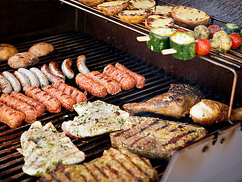 Selection of meat and vegetable skewers on a grill